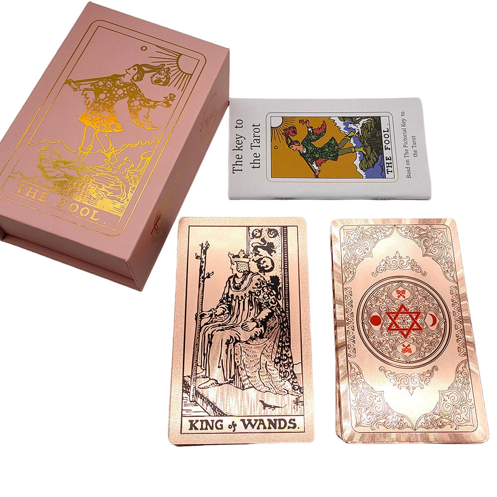 Tarot card deck, showing a black linework art on rose gold background on the back face of a card alongside a case and a booklet