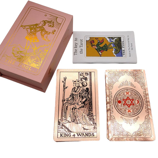 Tarot card deck, showing a black linework art on rose gold background on the back face of a card alongside a case and a booklet