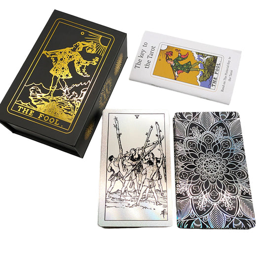 Tarot card deck, showing a pattern in black and silver on the back face of a card alongside a case and a booklet