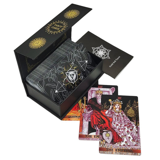 Tarot card deck, showing eye of providence with petals surrounding it on a black background on the back face of a card alongside a case and a booklet