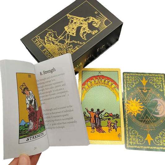 Tarot card deck, showing sun and moon on a green background on the back face of a card alongside a case and tarot meaning booklet